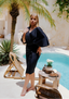 Profile view of the Ella Swim Set with Luna Skirt in black, showcasing the sleek and modest design of the one-piece swimsuit and short wrap skirt.