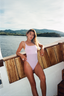 Modest-friendly one-piece swimsuit from the NAYA collection – pale lilac top and shiny ferritin bottom for stylish and modest swimwear lovers.